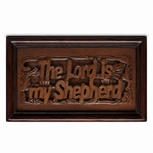 A rectangular hand-carved wooden plaque with a dark brown finish, featuring the carved text 'The Lord is my shepherd' in a stylized font, set against a plain white background.